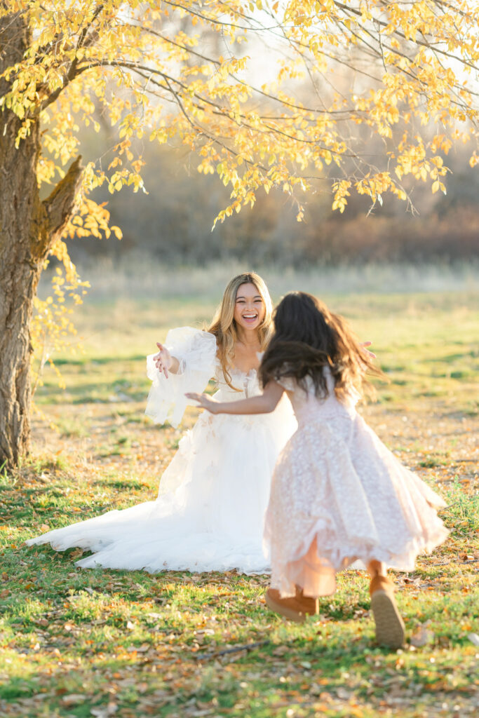 Mother and daughter running toward each other under golden trees while enjoying fall activities in Utah, photographed by Kamee Valdez Photo